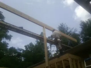 Carpenter setting a ridge beam over a new addition frame — Ice Dam Removal by Roofing Brothers in West Hurley
